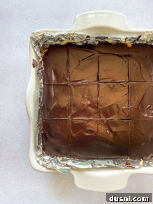 No-Bake Classic Nanaimo Bars 13 Chocolate ganache being poured over the custard layer of Nanaimo bars