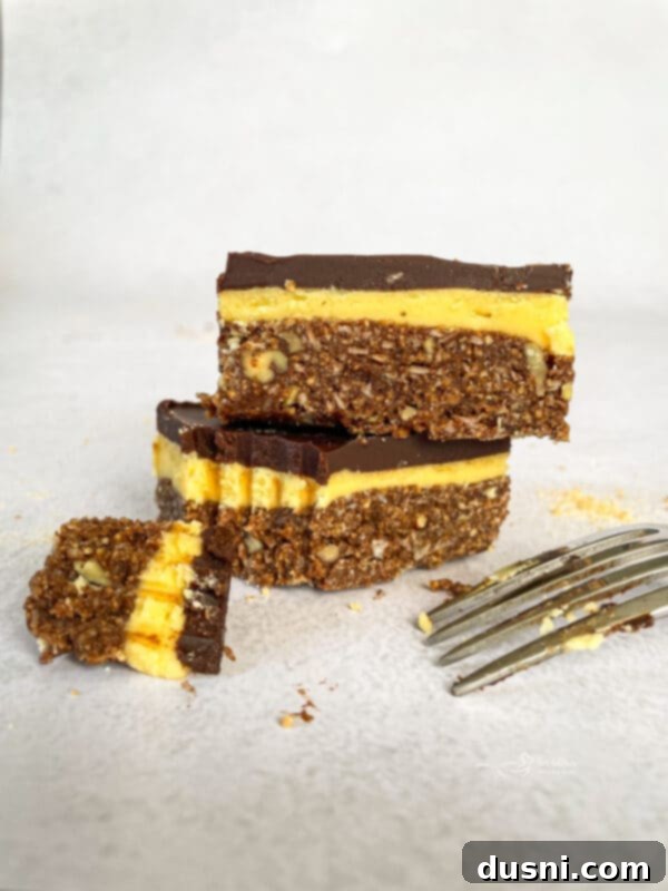 No-Bake Classic Nanaimo Bars 3 Close-up of Nanaimo bars with visible layers of chocolate, custard, and crumb crust