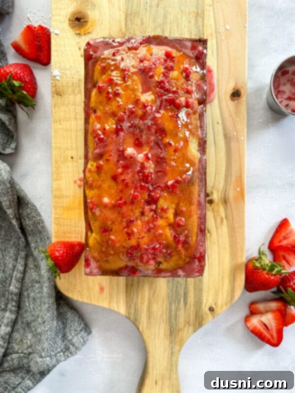 Cooling rack with a beautiful loaf of strawberry bread, preparing for glaze.