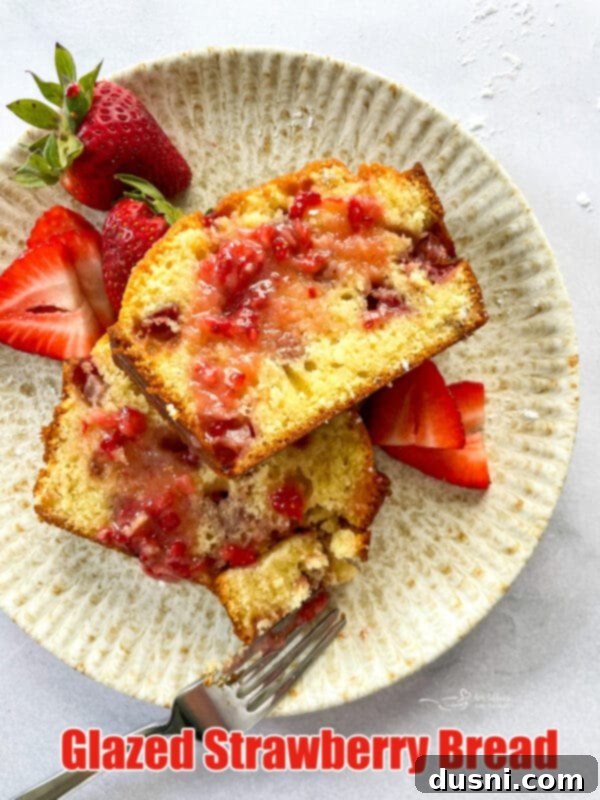 A stunning hero shot of Glazed Strawberry Bread, sliced and ready to serve, highlighting its moist texture and perfect glaze.