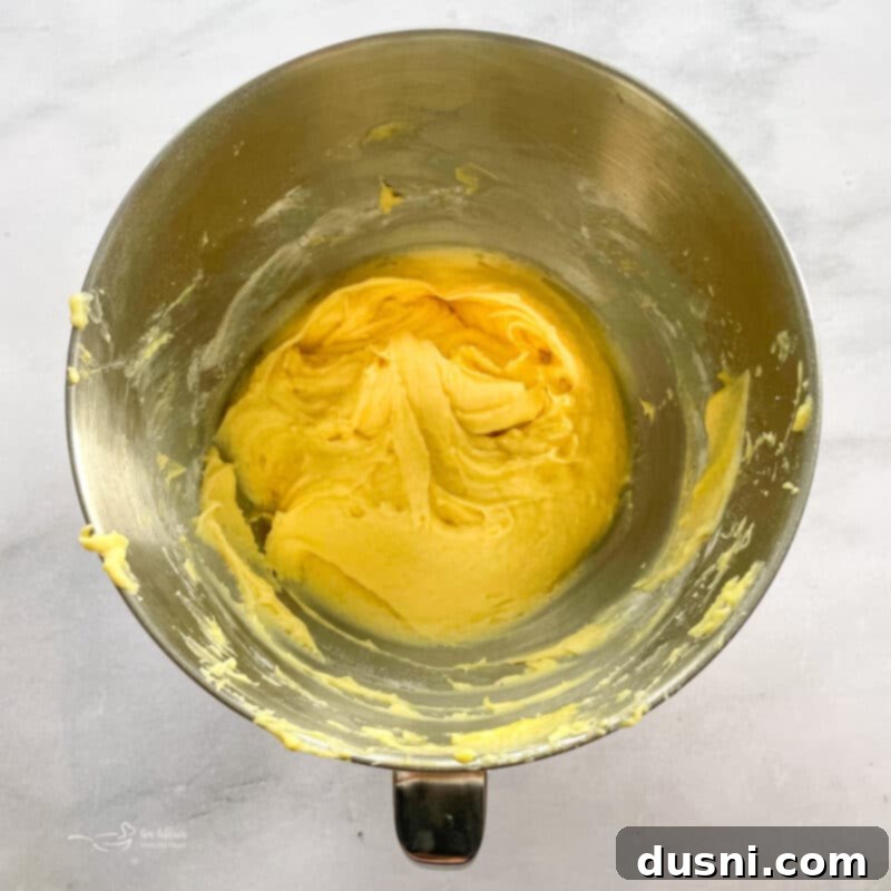 Creaming butter and sugar in a stand mixer bowl for strawberry bread.