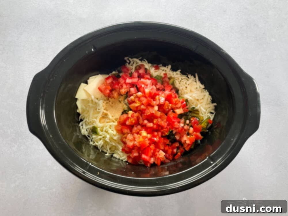 Homemade Qdoba Queso 12 Place shredded cheeses, roasted peppers, chopped tomatoes, cream and garlic into your slow cooker.