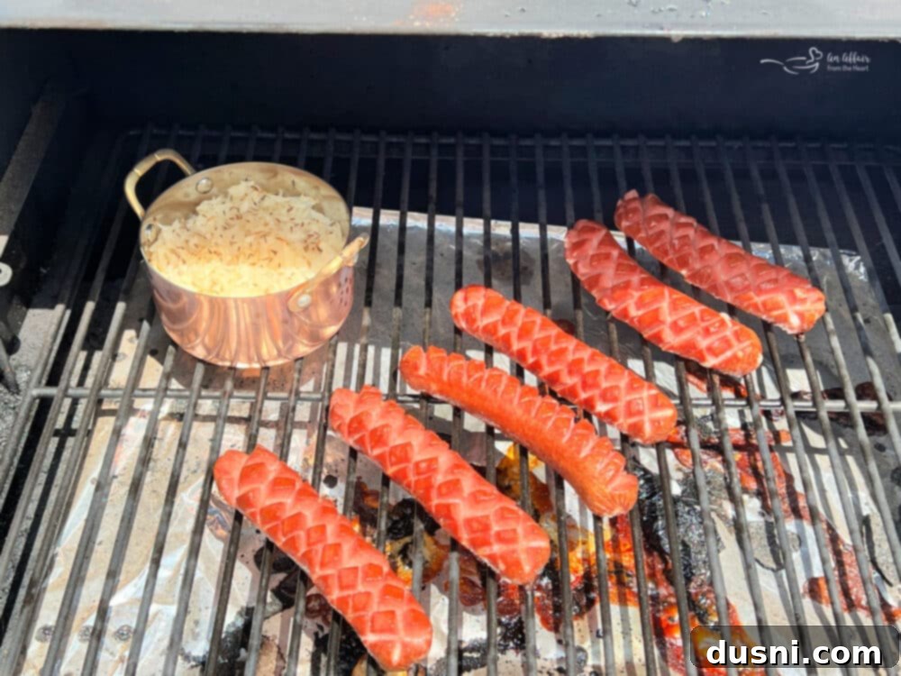 Smoky Franks with Tangy Kraut 13 Smoked hot dogs cooking on a grill with kraut