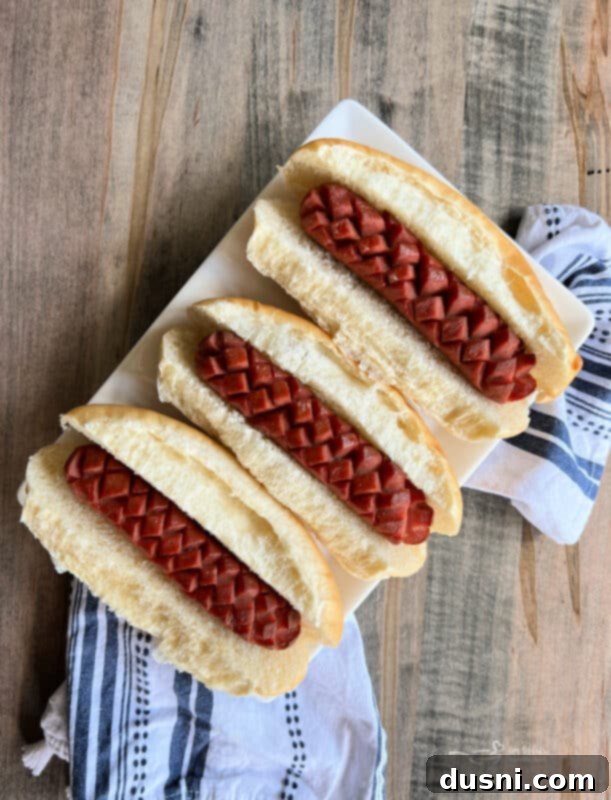 Smoky Franks with Tangy Kraut 5 Smoked hot dogs with scoring marks on a grill rack