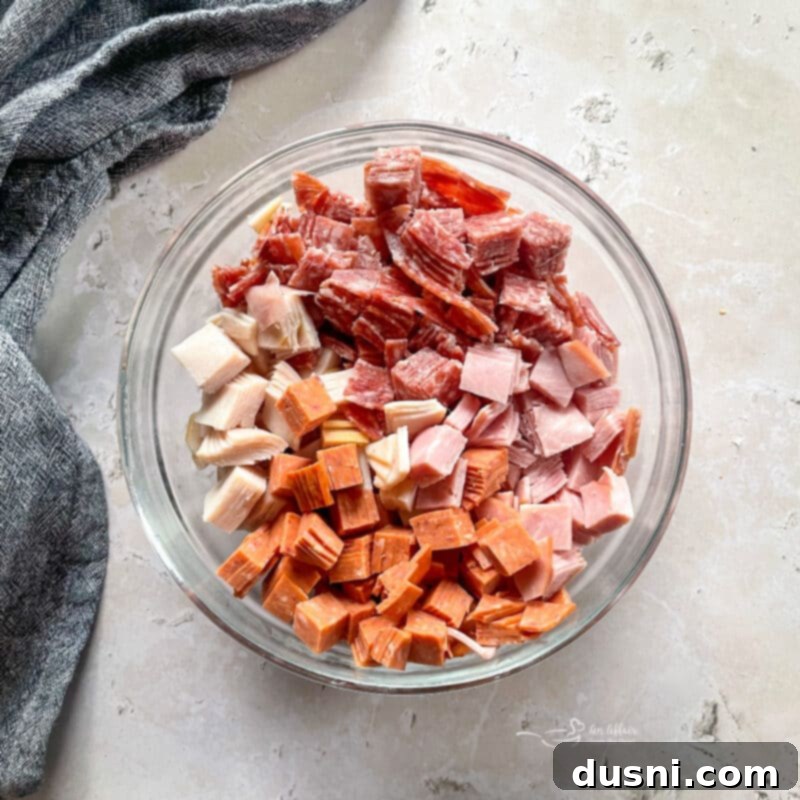 Close-up of deli meats and cheese being chopped for the salad.