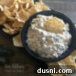 Close up of {Award Winning} Crack Dip in a black bowl with chips around it