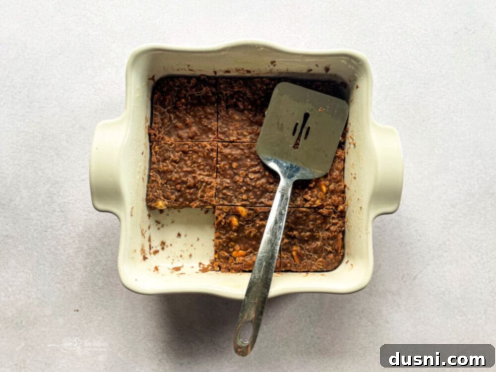 Pressing the no-bake cookie bar mixture into a prepared pan.