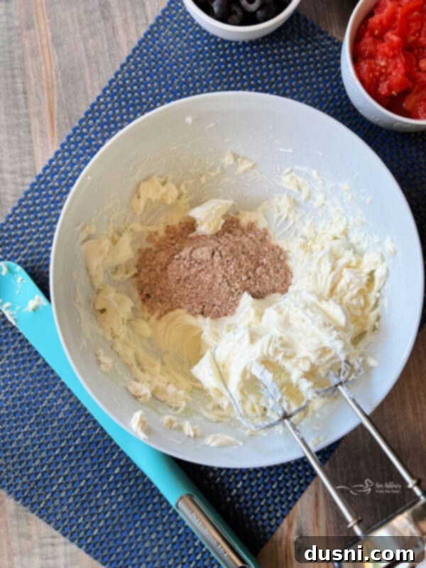 Easy 5 Ingredient Fiesta Corn Dip 4 Step one: Whipping softened cream cheese with Fiesta Ranch seasoning in a bowl.