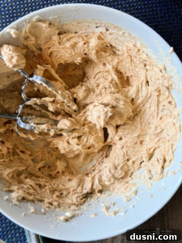 Easy 5 Ingredient Fiesta Corn Dip 5 Step one: Whipped cream cheese and Fiesta Ranch seasoning in a bowl, looking smooth.