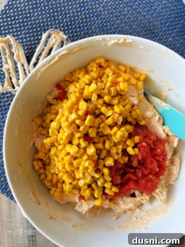 Easy 5 Ingredient Fiesta Corn Dip 6 Step two: Adding Rotel tomatoes and Mexicorn to the cream cheese mixture.