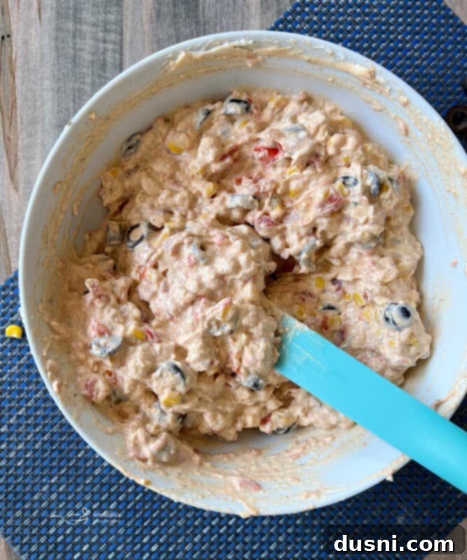 Easy 5 Ingredient Fiesta Corn Dip 9 Step four: Fiesta Corn Dip in a clear serving bowl, garnished with olives, ready to be served.