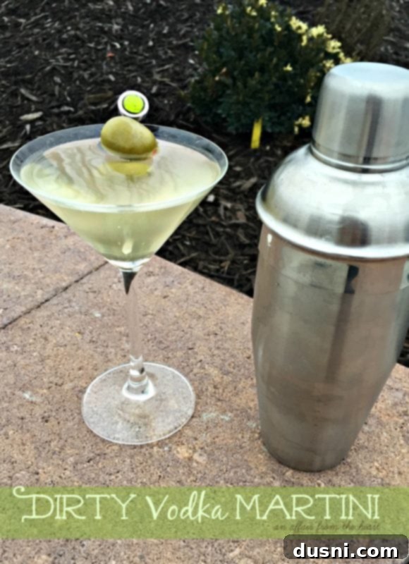 The Brine-Kissed Vodka Martini 4 Close-up of a dirty vodka martini, highlighting its clear liquid and green olives