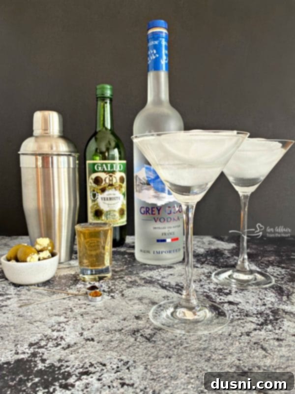 The Brine-Kissed Vodka Martini 7 Grey Goose Dirty Martini preparation, showing ingredients and shaker