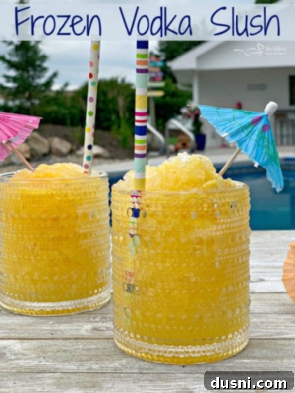 A vibrant frozen vodka slush in a glass, with a slice of lime and straw, ready to be enjoyed.