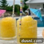 Side view of Frozen Vodka Slush with an umbrella and straw in it