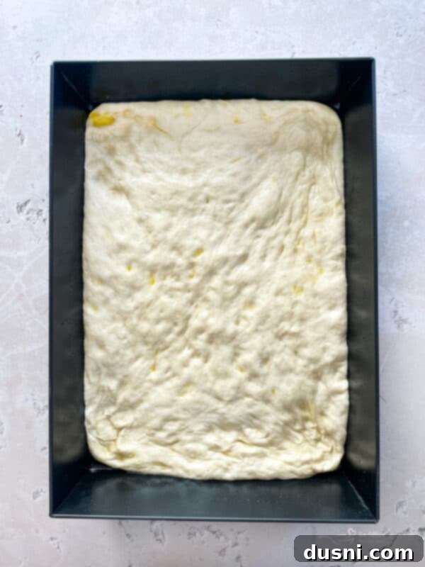 Homemade Detroit Style Pizza Perfection 11 Dimpling the Detroit Style Pizza dough into the pan.