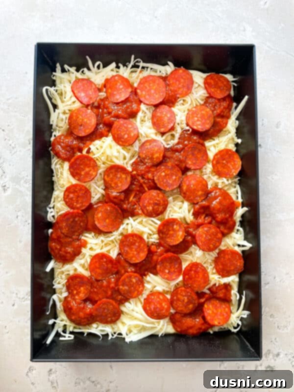 Homemade Detroit Style Pizza Perfection 13 Shredded mozzarella cheese spread to the edges of the Detroit Style Pizza dough.