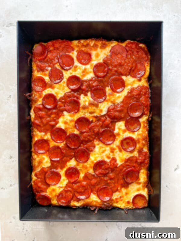 Homemade Detroit Style Pizza Perfection 14 Detroit Style Pizza topped with sauce stripes and pepperoni, ready for baking.
