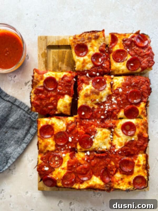 Homemade Detroit Style Pizza Perfection 17 Close-up of a Detroit Style Pizza slice with crispy edges and melted cheese.