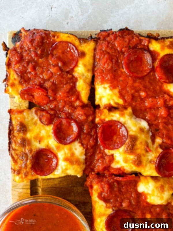 Homemade Detroit Style Pizza Perfection 6 Detroit Style Pizza with sauce stripes and pepperoni on top of melted cheese.
