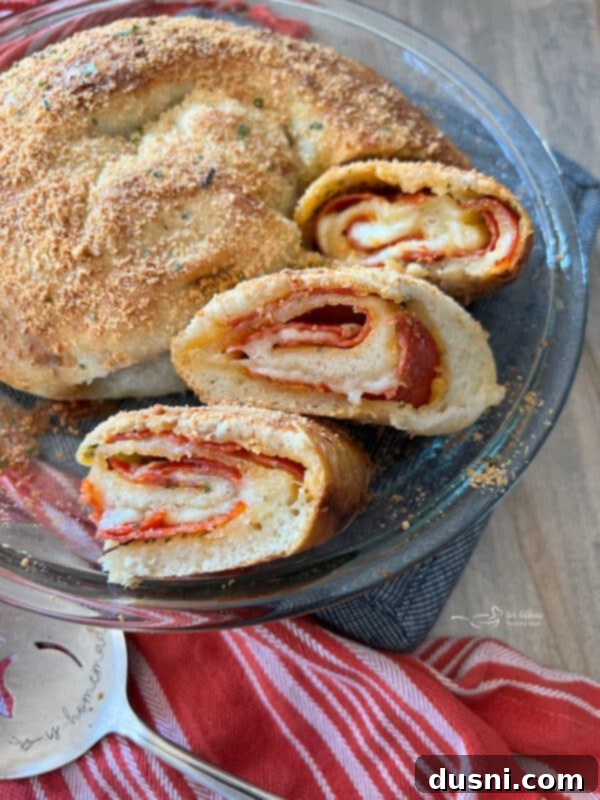 Close-up of freshly baked pepperoni pizza bread, sliced and showing the layers of pepperoni and cheese, with a golden-brown crust.