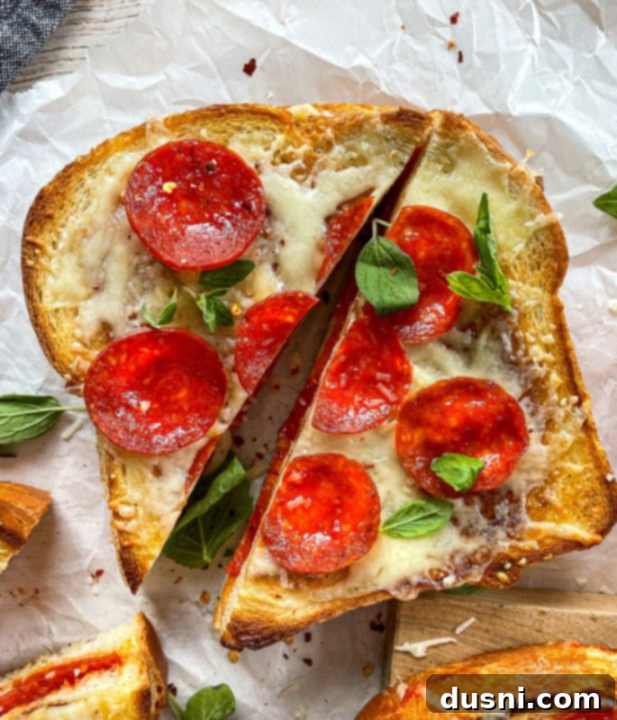 Pepperoni Pizza Grilled Cheese sandwich cut in half, showing melted cheese and pepperoni.