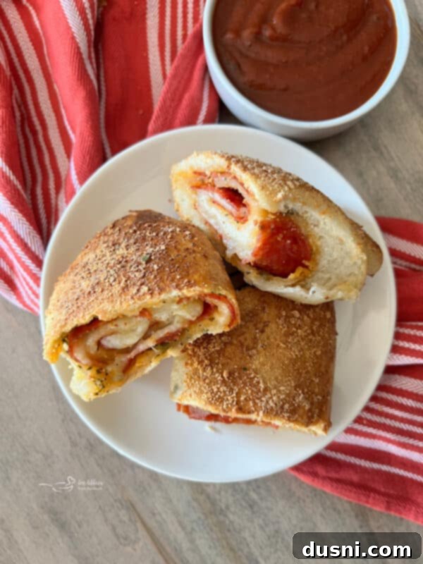 Ingredients for pepperoni pizza bread laid out on a pastry mat: pizza dough, pepperoni, mozzarella, herbs, and spices.