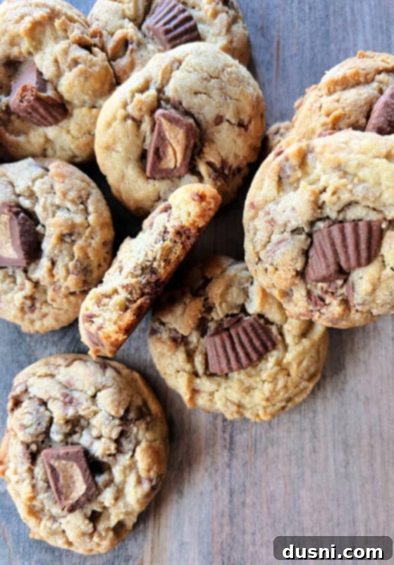 Ultimate Reese's Peanut Butter Cookies 2 Freshly baked Reese's Peanut Butter Cup Cookies on a cooling rack, showcasing melted peanut butter cups and golden-brown edges.