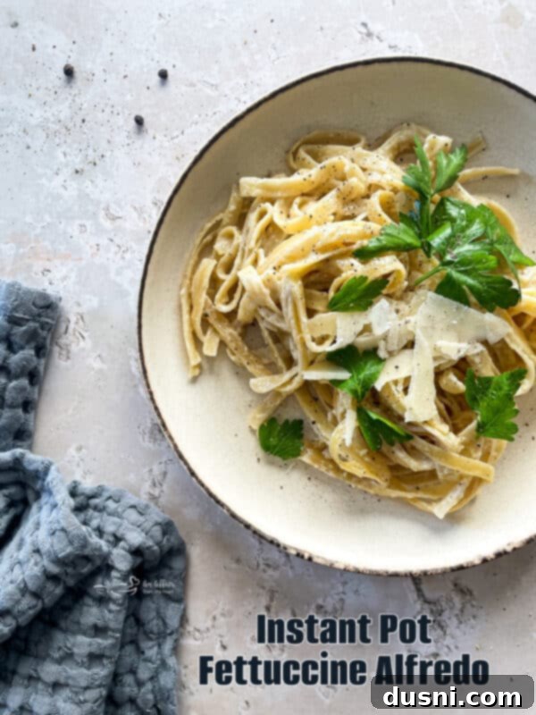 A vibrant, close-up shot of Instant Pot Fettuccine Alfredo in a white bowl.