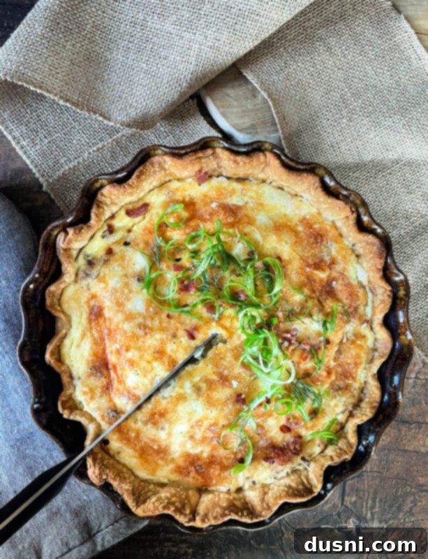 Close-up of baked Bacon and Swiss Quiche in a pie dish, golden brown