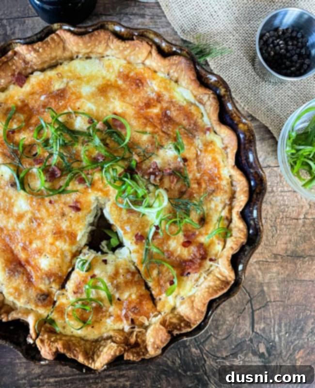 Close-up of a slice of Bacon and Swiss Quiche showing the layers of bacon, cheese, and creamy egg filling