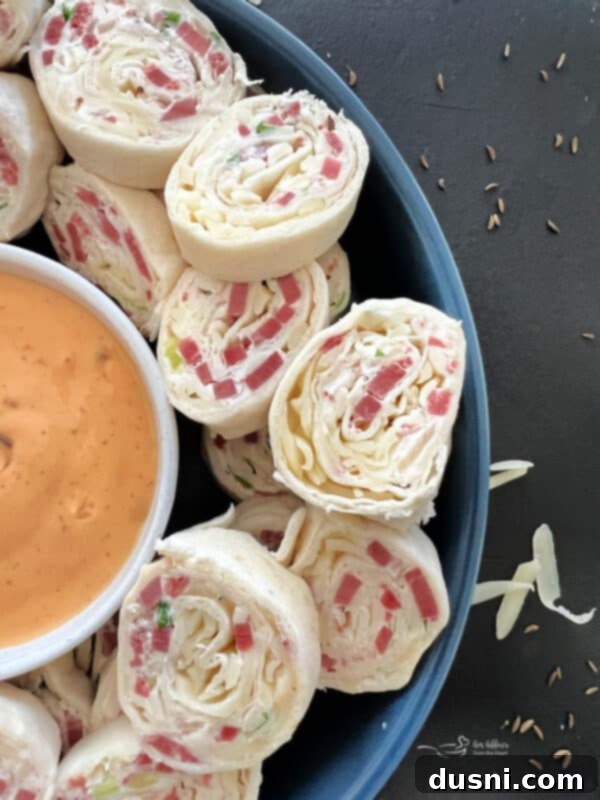 A plate of freshly sliced Reuben Style Tortilla Roll-Ups, showcasing the layers of filling and golden-brown tortillas, ready to be served at a party or gathering.