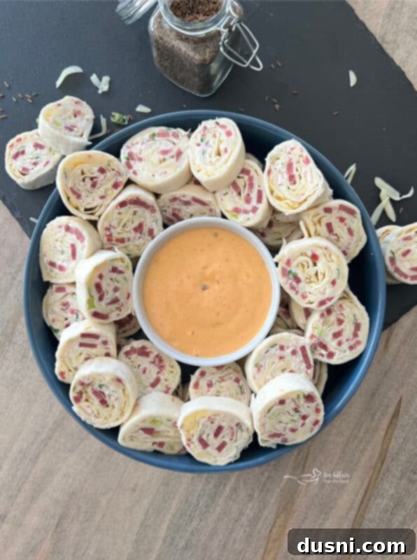 Reuben Style Tortilla Roll-Ups arranged on a wooden board, showcasing their appealing spiral shape and delicious filling.
