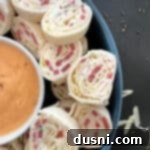 Reuben Style Tortilla Roll-Ups in a blue bowl with dressing