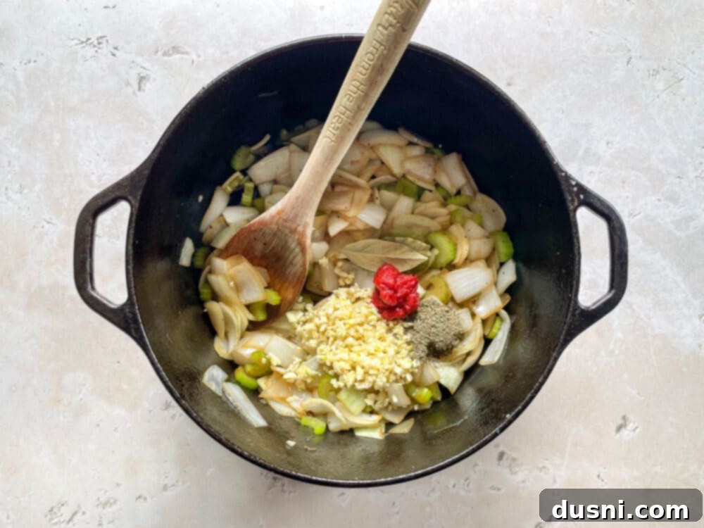 Homemade Bob Evans Style Pot Roast 10 Adding tomato paste, garlic, thyme, and bay leaves to vegetables in a Dutch oven.