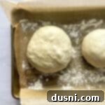 Artisan Pizza Base 13 Rolled dough balls on a parchment lined baking sheet.