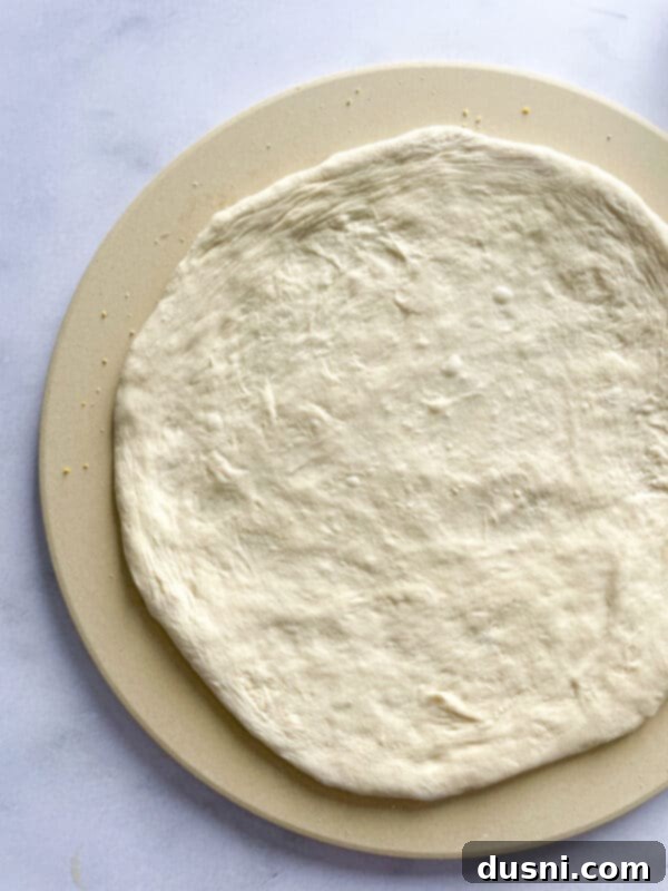 Artisan Pizza Base 8 Performing the finger dent test on proofed pizza dough to check readiness.