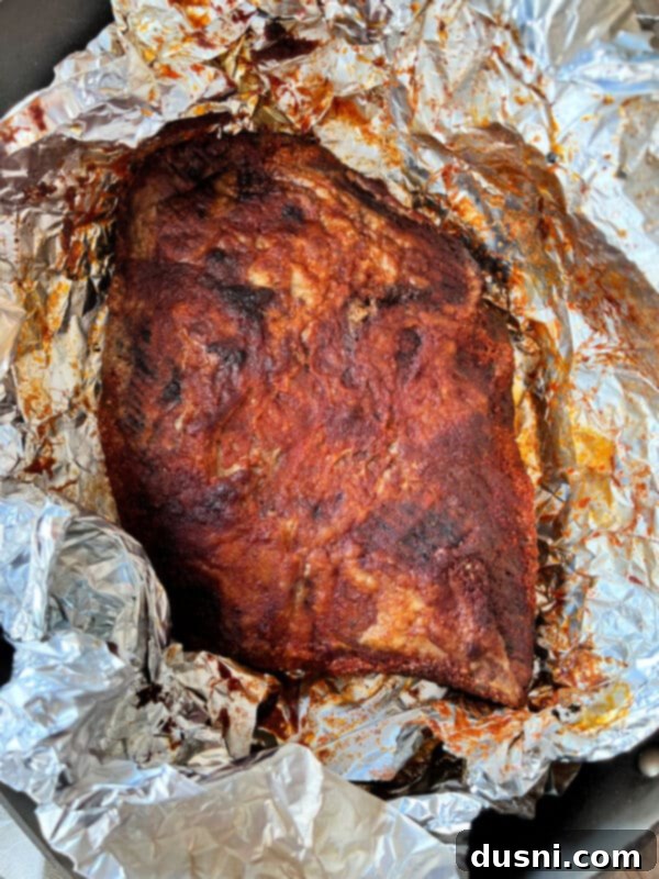 Texas Heat Smoked Brisket 11 Cooked spicy beef brisket removed from the smoker and resting in foil.