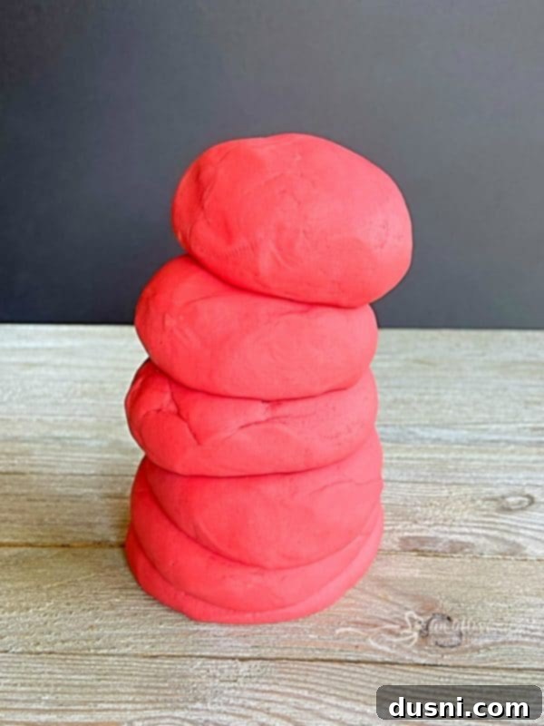 Stack of homemade playdough in various Kool-Aid colors