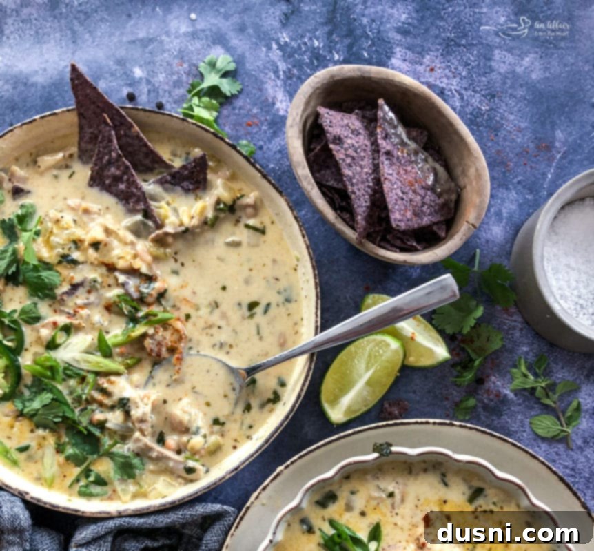 Creamy White Chicken Chili 7 A pot of white chicken chili simmering on the stovetop, with steam gently rising.
