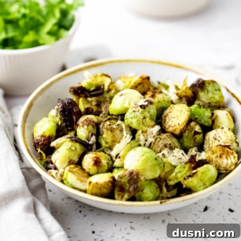A bowl of fresh Brussels sprouts and a bottle of olive oil, ingredients for air frying.