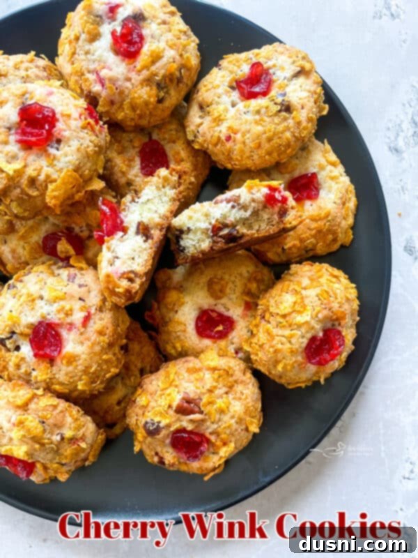A large stack of Cherry Wink Cookies on a white plate, with a decorative napkin.