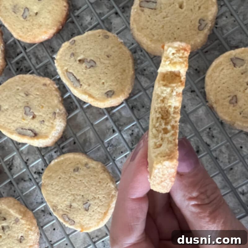 Orange Ginger Refrigerator Cookies stacked high on a wooden cutting board.