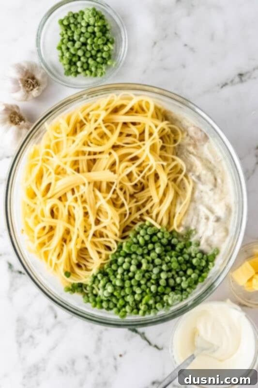 Hearty Leftover Turkey Pasta Bake 8 Cooked linguine being stirred into the creamy sauce mixture for the Turkey Pasta Bake.