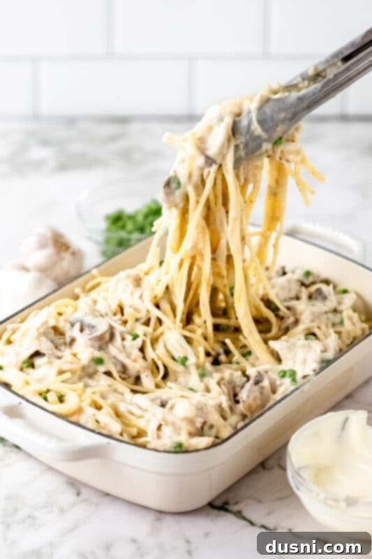 Hearty Leftover Turkey Pasta Bake 9 Frozen peas being stirred into the Turkey Pasta Bake mixture in a large bowl.