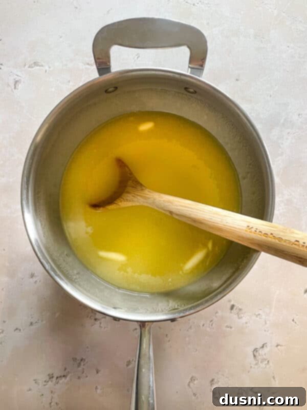A baking dish lined with parchment paper, buttered and ready for the caramel mixture.