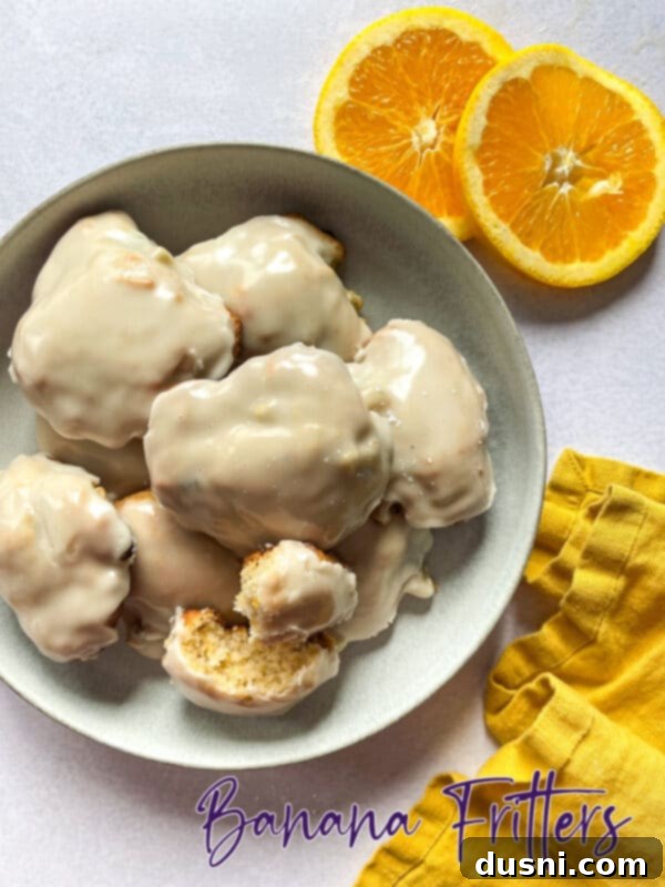 Golden Baked Banana Bites 18 Beautifully arranged baked banana fritters on a white plate, garnished with mint.