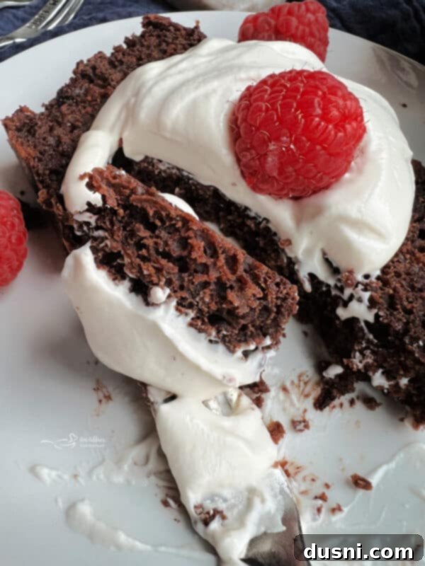 The Sauerkraut Secret Chocolate Pound Cake 16 A slice of chocolate sauerkraut pound cake with fresh berries on a white plate