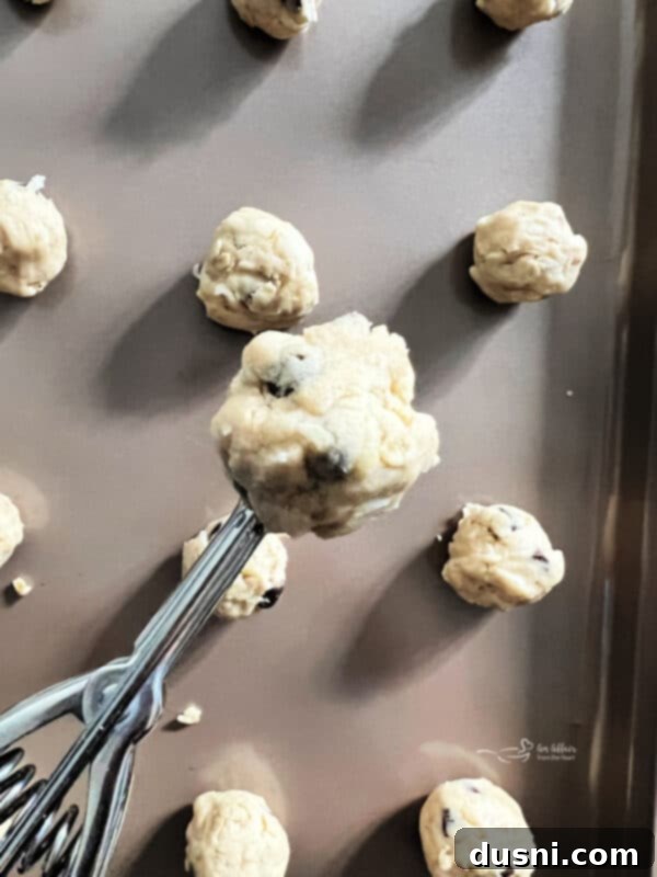 Mom's Homemade Delights 11 Cookie dough on a parchment-lined baking sheet.