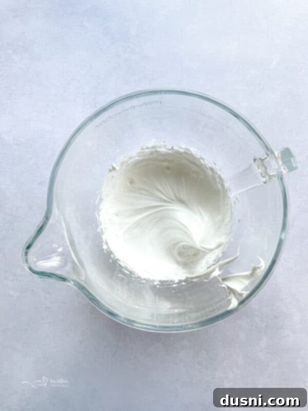 Egg whites, salt, and cream of tartar in a mixing bowl before whipping.
